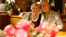 Seorang pelayan asal Jerman, Kathi Kink duduk bersama seorang tamu di restoran 'Zum Goldenen Tal' di Weyarn, Jerman. Foto diambil pada 1 Februari 2015. (REUTERS/Michaela Rehle)