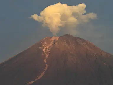 Gunung Semeru menyemburkan asap tipis terlihat dari desa Curah Kobokan di Lumajang, Jawa Timur, Rabu (8/12/2021).  Sebelumnya, Gunung Semeru pada 4 Desember 2021 lalu mengalami erupsi sekitar pukul 15.00 WIB. (ADEK BERRY / AFP)