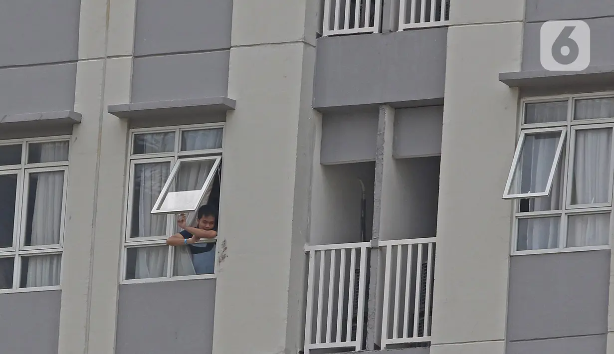 Pasien berstatus OTG (Orang Tanpa Gejala) berdiri di jendela Rumah Sakit Darurat Wisma Atlet Kemayoran, Jakarta, Selasa (26/1/2021). Hari ini, Selasa (26/1) kasus COVID-19 di Indonesia bertambah 13.094 sehingga total menyentuh angka satu juta, tepatnya 1.012.350. (Liputan6.com/Herman Zakharia)