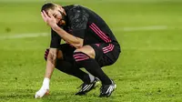 Penyerang Real Madrid, Karim Benzema, tampak kecewa usai gagal mengalahkan Elche pada laga Liga Spanyol di Stadion Manuel Martinez Valero, Rabu (30/12/2020). Kedua tim bermain imbang 1-1. (AP/Jose Breton)