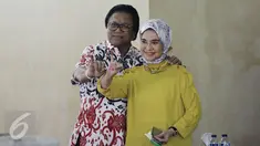 Ketua DPD RI Oesman Sapta Odang atau Oso di dampingi Istri Serviati Oesman menunjukan jarinya usai menggunakan hak pilihya dalam Pilkada Putaran kedua di TPS 03 Denpasar, Kuningan Timur, Jakarta, Rabu (19/4). (Liputan6.com/Johan Tallo)