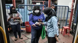 Calon penumpang menunjukkan sertifikat vaksin melalui aplikasi Peduli Lindungi kepada petugas sebelum menaiki bus listrik Transjakarta di Terminal Blok M, Jakarta, Kamis (4/11/2021). (merdeka.com/Iqbal S. Nugroho)