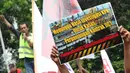 Pekerja yang tergabung dalam FPPI dan Serikat Pekerja JICT membentangkan poster saat unjuk rasa di depan Gedung KPK, Jakarta, Selasa (9/5). Pekerja meminta kepada investor Hongkong Hutchison port untuk bertanggung jawab. (Liputan6.com/Helmi Afandi)