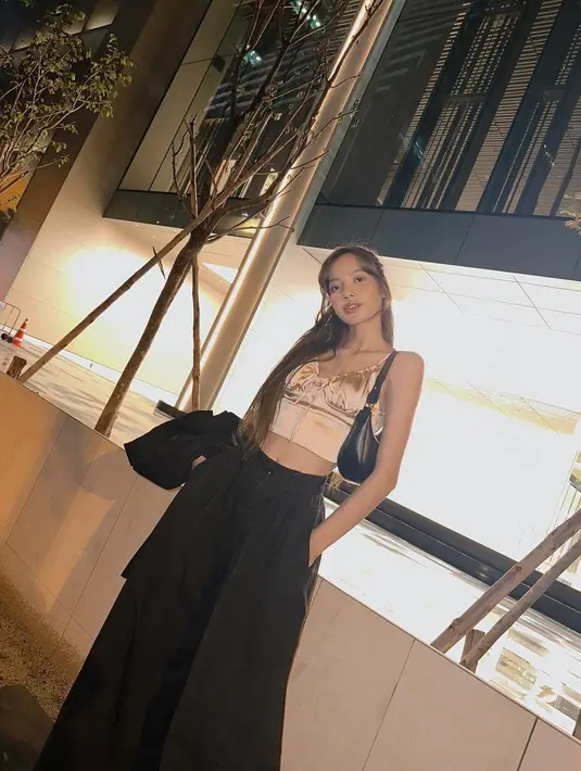 Muncul dengan makeup natural, Lisa tampil kekinian dengan padu padan silk crop top dan high waist pants.