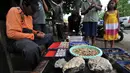 Seorang pedangang saat menjajakan batu khas Nusakambangan, Jawa Tengah, Sabtu (7/3/2015). Maraknya berita hukuman mati di lapas nusakambangan menjadi rejeki bagi warga Desa Wijaya Pura dengan batu-batu khas nusakambangan (Liputan6.com/Johan Tallo)