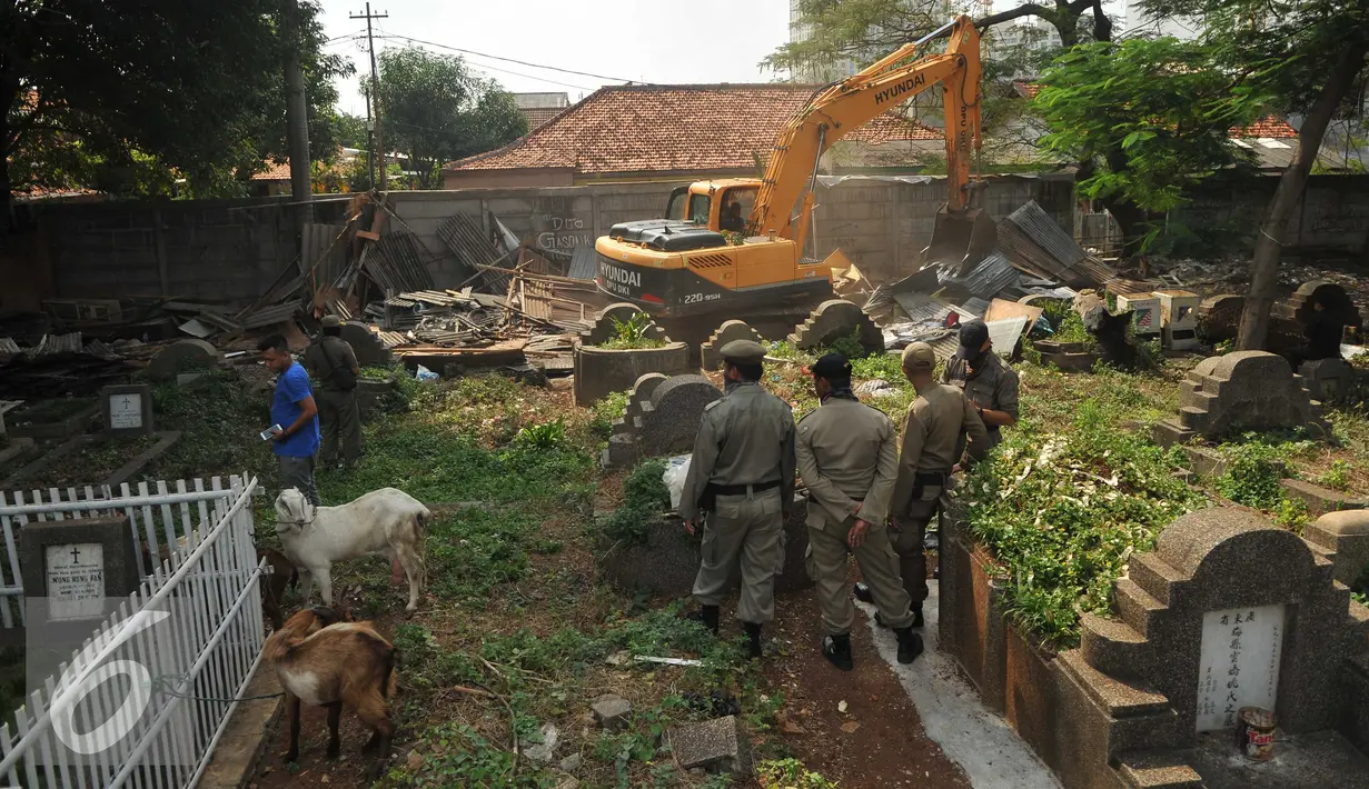 Petugas menggunakan kendaraan alat berat membongkar bangunan liar di kawasan TPU Menteng Pulo, Jakarta Selatan (7/4). Sebanyak 225 bangunan liar semi-permanen dibongkar karena berdiri di atas lahan TPU. (Liputan6.com/Gempur M Surya)