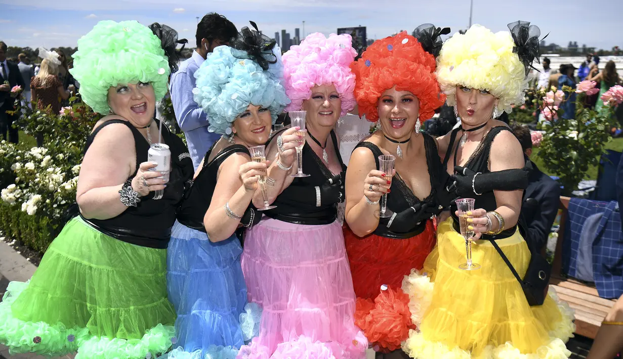 Sejumlah wanita mengenakan kostum unik sebelum pertandingan pacuan kuda Piala Melbourne di Melbourne (5/11/2019). Para wanita tampil cantik dan modis dengan hiasan kepala yang mereka gunakan selama menyaksikan balap kuda di Melbourne Cup.  (AFP Photo/William West)