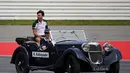 Kamui Kobayashi, pembalap Formula Satu asal Jepang ikut berparade mengelilingi Sirkuit Hockenheim menggunakan mobil antik, (20/7/2014). (REUTERS/Michael Dalder)