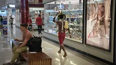 Anggota suku Kariri berjalan di sebuah mal di Brasilia (26/8/2021).  Ia masuk ke dalam mal saat para pengunjuk rasa suku pribumi lainnya berkumpul di ibu kota Brasil saat Mahkamah Agung bersiap untuk menangani kasus yang dapat menghilangkan keberatan di tanah leluhur mereka. (AFP/Carl De Souza)