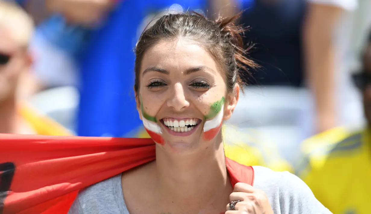 Seorang suporter cantik asal Italy antusias memberikan dukungan kepada timnya saat melawan Swedia pada laga grup E Euro Cup 2016 di Stadion Municipal, Toulouse, Jumat (17/6/2016) WIB. (AFP/Vincenzo Pinto)