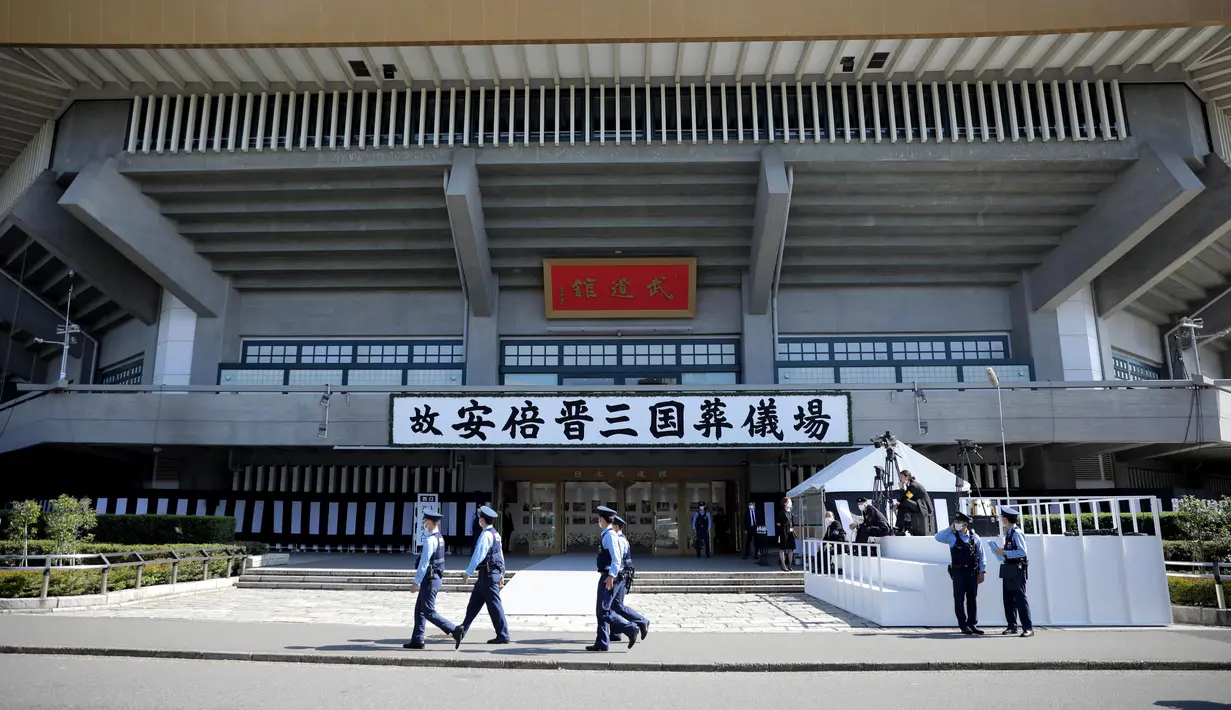 Petugas polisi berpatroli di luar Nippon Budokan, tempat pemakaman kenegaraan mantan Perdana Menteri Jepang Shinzo Abe, di Tokyo Selasa, 27 September 2022. Pemakaman Abe akan berlangsung di Nippon Budokan, Tokyo sekitar pukul 14.00 waktu lokal. (Kyodo News via AP)