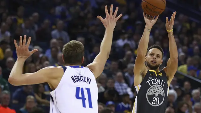 Stephen Curry (hitam) melepaskan tembakan saat Warriors menghajar Mavericks