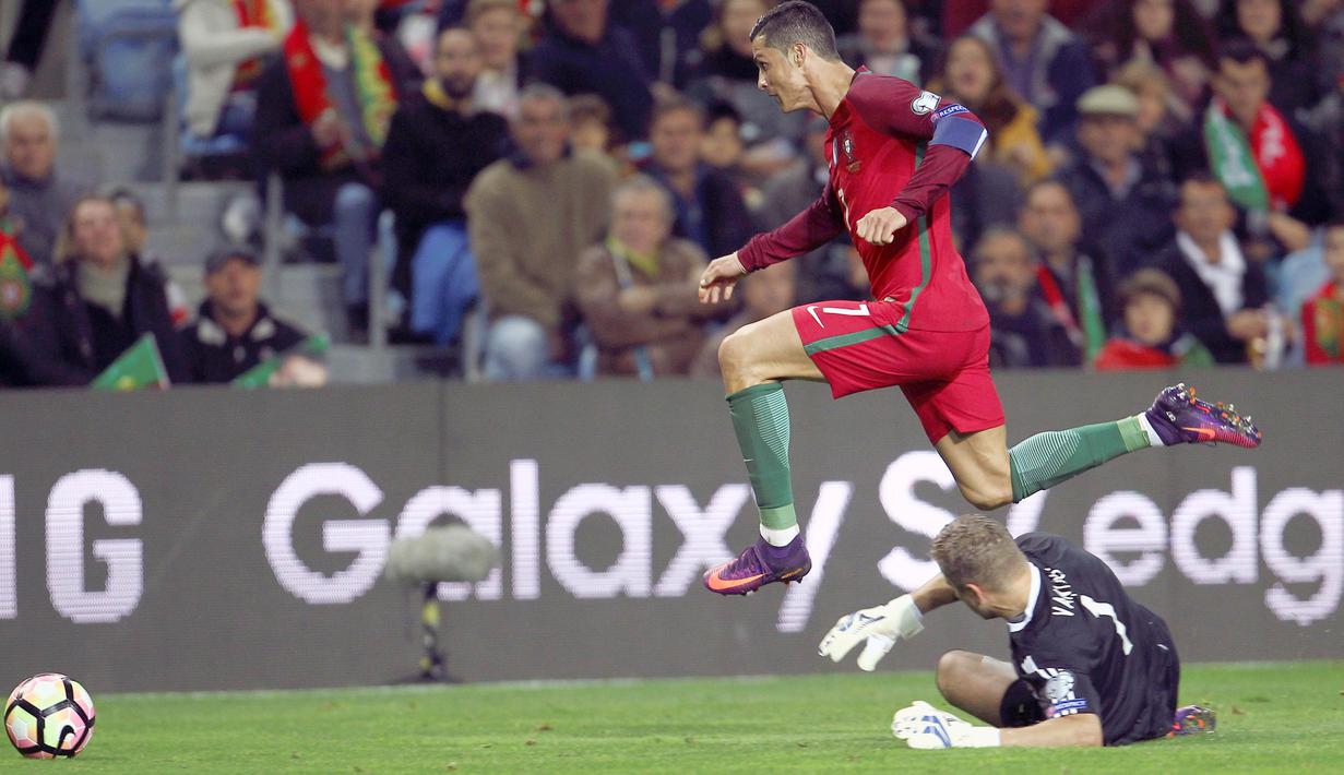 Aksi Cristiano Ronaldo melewati kiper Latvia pada laga Kualifikasi Piala Dunia 2018 di Algarve stadium, Faro (13/11/2016). Portugal menang 4-1. (Reuters/Pedro Nunes )