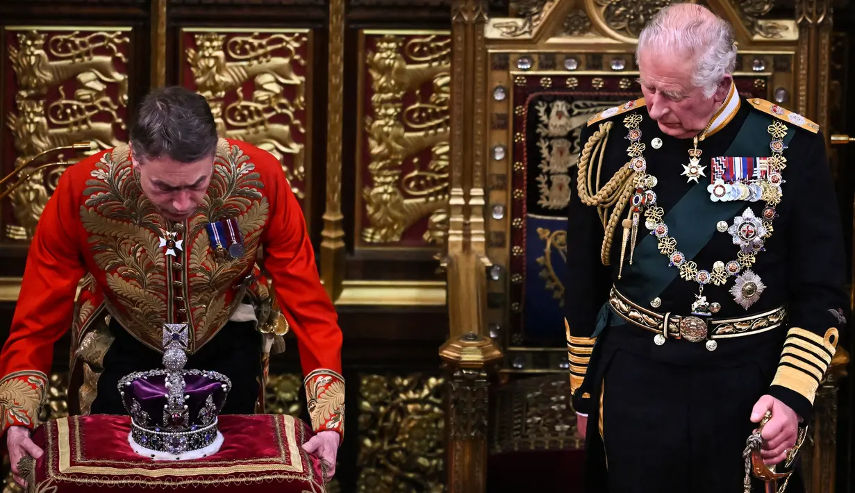 <p>Dalam file foto ini diambil pada 10 Mei 2022 Pangeran Charles Inggris, Prince of Wales (kanan) melihat Mahkota Negara Kekaisaran (kiri) dihapus setelah membaca Pidato Ratu di Kamar House of Lords selama Pembukaan Negara Parlemen di Gedung Parlemen, di London. Sebagai raja baru Inggris, Charles III mengatakan bahwa Ratu Elizabeth II adalah penguasa yang disayangi serta ibu yang sangat dicintai dan akan dirindukan di seluruh dunia. (AFP/Ben STANSALL)</p>