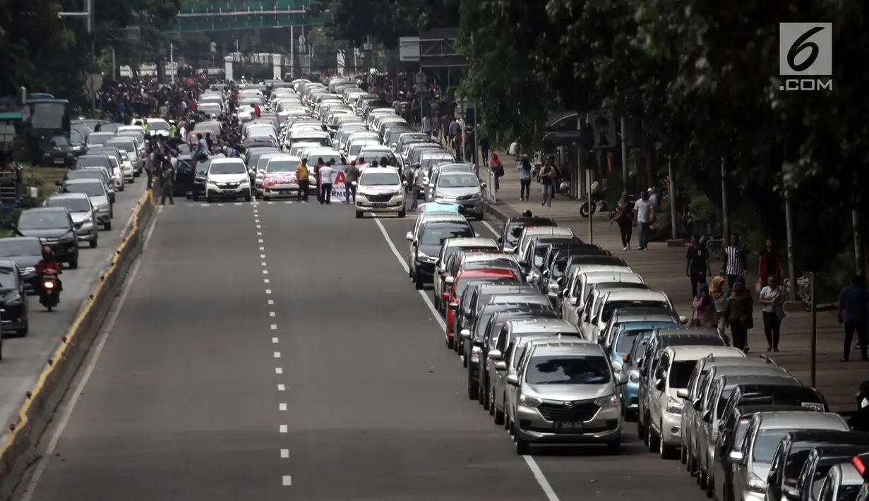 Suasana saat ratusan sopir taksi online memarkir mobilnya di Jalan Medan Merdeka Barat, Jakarta, Rabu (14/2). Para pengemudi menolak Permenhub Nomor 108 karena dianggap memberatkan. (Liputan6.com/Arya Manggala)