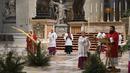 Paus Fransiskus memegang ranting pohon palem saat memimpin Misa Minggu Palma di St. Peter's Basilica, Vatikan, Minggu (5/4/2020). Misa hanya diikuti sejumlah petugas yang tetap menjaga jarak untuk menghindari penyebaran virus corona COVID-19. (AP Photo/pool/Alberto Pizzoli)