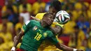 Gelandang Brasil, Luiz Gustavo (belakang) berebut bola dengan pemain tengah Kamerun, Enoh Eyong, saat berlaga di penyisihan Piala Dunia 2014 Grup A di Stadion Nasional Brasil, (24/6/2014). (REUTERS/Michael Dalder)