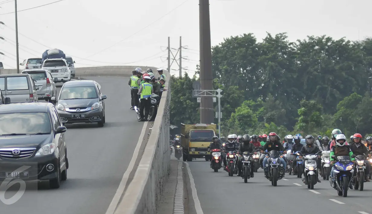 Petugas menilang pengendara motor yang melintas di Flyover Pesing arah Kalideres, Jakarta, ketika Operasi Patuh Jaya, Rabu (18/5). Razia dilakukan untuk mengantisipasi sepeda motor yang melawan arus dan masuk jalur flyover. (Liputan6.com/Gempur M Surya)