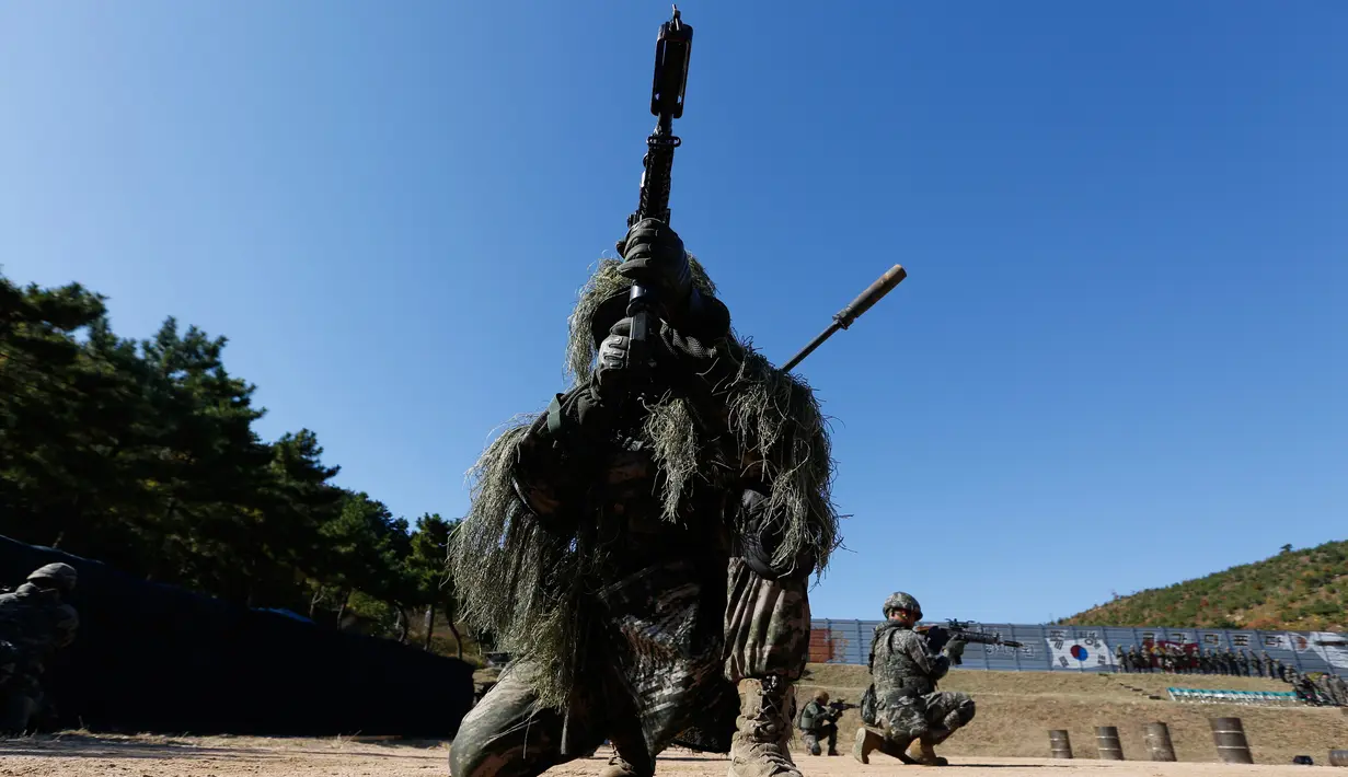 Seorang marinir beraksi selama latihan reguler di Pulau Yeonpyeong, Korea Selatan (1/11). Zona larangan terbang dan larangan latihan militer di dekat perbatasan yang dijaga ketat antara Korut dan Korsel mulai berlaku hari ini. (AP Photo/Jeon Heon-kyun)
