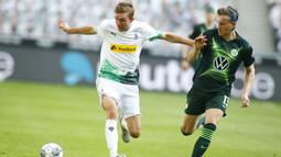 Gelandang Borussia Monchengladbach, Christoph Kramer, berebut bola dengan bek Wolfsburg, Yannick Gerhardt, pada laga lanjutan Bundesliga di Borussia Park Stadium, Rabu (17/6/2020) dini hari WIB. Monchengladbach menang telak 3-0 atas Wolfsburg.(AFP/Thilo Schmuelgen/pool)