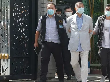 Taipan media Hong Kong, Jimmy Lai (tengah) ditangkap oleh petugas polisi di rumahnya di Hong Kong, Senin (10/8/2020). Pendiri surat kabar lokal Apple Daily itu ditangkap atas tuduhan pelanggaran Undang-Undang Keamanan Nasional Hong Kong karena dianggap berkolusi dengan kekuatan asing. (AP Photo)
