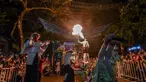 Orang-orang yang bersuka ria tampil selama parade Mitos dan Legenda di Medellin, departemen Antioquia, Kolombia (8/12/2021). Parade mitos dan legenda adalah bagian penting dari acara ini di sebagian besar kota dan kotamadya Kolombia. (AFP/Joaquin Sarmiento)