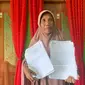 Suarni Pido, salah satu warga Desa Moutong saat menunjukan dokumen terkait dengan kepala desa (Arfandi Ibrahim/Liputan6.com)
