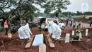 Petugas mengenakan alat pelindung diri dan baju hazmat saat proses pemakaman protap Covid-19 di TPU Pondok Ranggon, Jakarta, Senin (28/9/2020). (merdeka.com/Iqbal S. Nugroho)