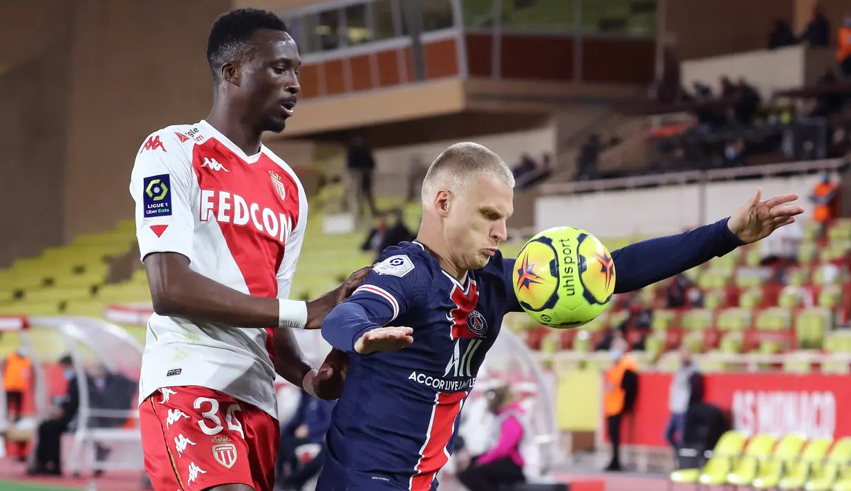Bek PSG, Mitchel Bakker, Berebut bola dengan bek AS Monaco, Chrislain Matsima, pada laga lanjutan Liga Prancis di Stadion Stade Louis II, Sabtu (21/11/2020) dini hari WIB. PSG takluk 2-3 oleh AS Monaco. (AFP/Valery Hache)
