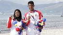 Atlet modern pentathlon, Muhammad Taufik dan Dea Salsabila, berpose usai meraih medali pada nomor beach triathle individual SEA Games 2019 di Subic, Jumat (6/12). Taufik meraih perunggu dan Dea meraih emas. (Bola.com/M Iqbal Ichsan)