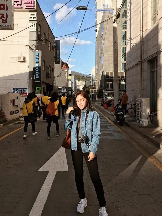Liburan ke Korea, aktris cantik ini menyempatkan diri berfoto di jalanan Kota Busan. Tampil menggunakan jaket denim dan celana hitam membuatnya terlihat sangat santai. Sepatu putih dan tas coklat melengkapi penampilannya dengan kamera yang di gantung di leher. (Liputan6.com/IG/faynabilalxndr)