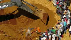 Petugas penyelamat saat mencari para korban longsor ditumpukan tanah di lokasi tambang Hpakant giok, Myanmar, (21/11). Longsor terjadi disebuah perkemahan kumuh yang berada tepat disebelah pertambangan. (REUTERS/Stringer)