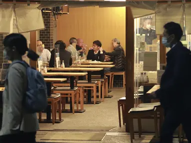 Orang-orang makan di sebuah restoran di Tokyo, Jepang, Senin (25/10/2021). Pemerintah Metropolitan Tokyo mencabut seluruh pembatasan di tempat-tempat makan menyusul penurunan jumlah kasus corona COVID-19 harian di negara itu. (AP Photo/Koji Sasahara)