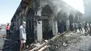 Orang-orang berkumpul melihat kondisi masjid yang terdapat makam Sayid Muhammad bin Ali al-Hadi di Balad usai terkena serangan bom bunuh diri, Baghdad, Irak (8/7). Dikabarkan 30 orang tewas dalam peristiwa tersebut. (REUTERS / Thaier Al-Sudani)