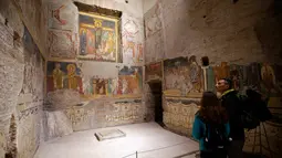 Pengunjung saat melihat lukisan dinding gereja Santa Maria Antiqua, Roma, Italia, 17 Maret 2016. Penemuan lukisan-lukisan ini telah memberikan banyak teori tentang perkembangan awal seni abad pertengahan. (REUTERS / Max Rossi)