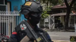 Polisi berjaga di lokasi gereja setelah ledakan di Makassar (28/3/2021).  Ledakan terjadi sekitar pukul 10.28 Wita tepat saat sejumlah jemaah gereja tengah beribadah. (AFP/Indra Abriyanto)