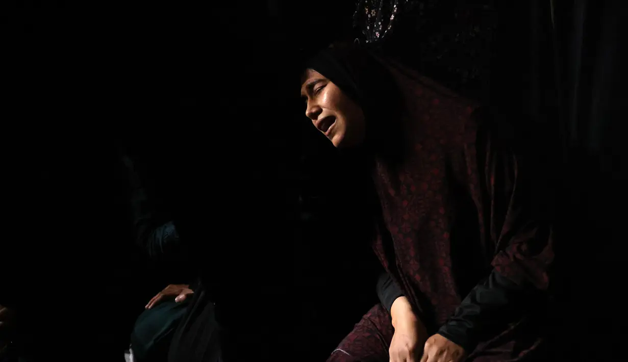 Kerabat berduka atas jenazah Tareq al-Qadi, yang tewas sehari sebelumnya dalam serangan udara Israel, selama pemakamannya di Rafah, Jalur Gaza selatan, Senin (17/5/2021). Tercatat, ada 212 penduduk Jalur Gaza, Palestina kehilangan nyawa di antaranya 61 korban merupakan anak-anak. (SAID KHATIB/AFP)