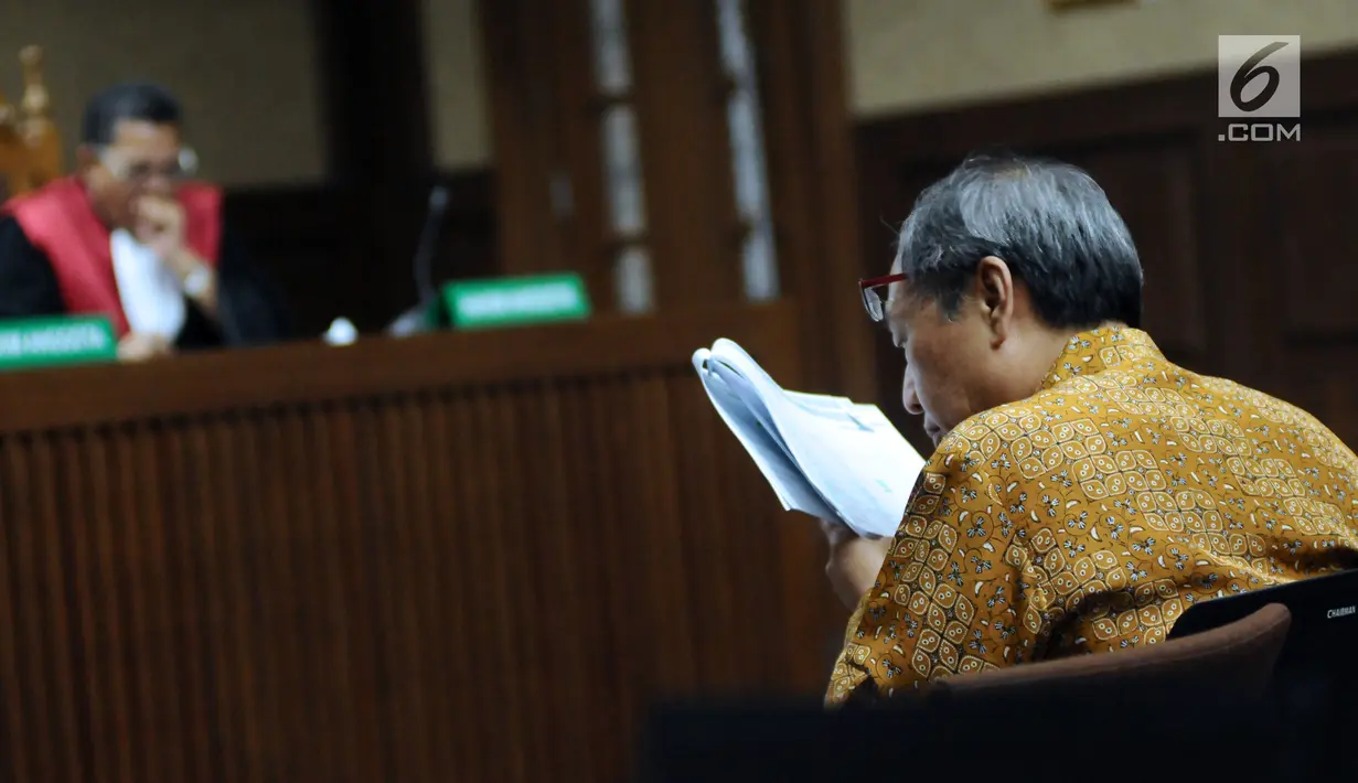Pengusaha Made Oka Masagung membaca catatan pada sidang lanjutan dugaan korupsi proyek e-KTP dengan terdakwa Setya Novanto di Pengadilan Tipikor, Jakarta, Senin (22/1). Sidang menghadirkan sejumlah saksi. (Liputan6.com/Helmi Fithriansyah)