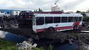 Kondisi sebuah bus yang dihantam kereta ketika melintasi rel dekat wilayah Sidi Fathallah, sekitar 10 km selatan Ibu Kota Tunisia, Rabu (28/12). Bus itu terbelah dua ketika dihantam kereta dan menyebabkan lima orang tewas. (Fethi Belaid/AFP)