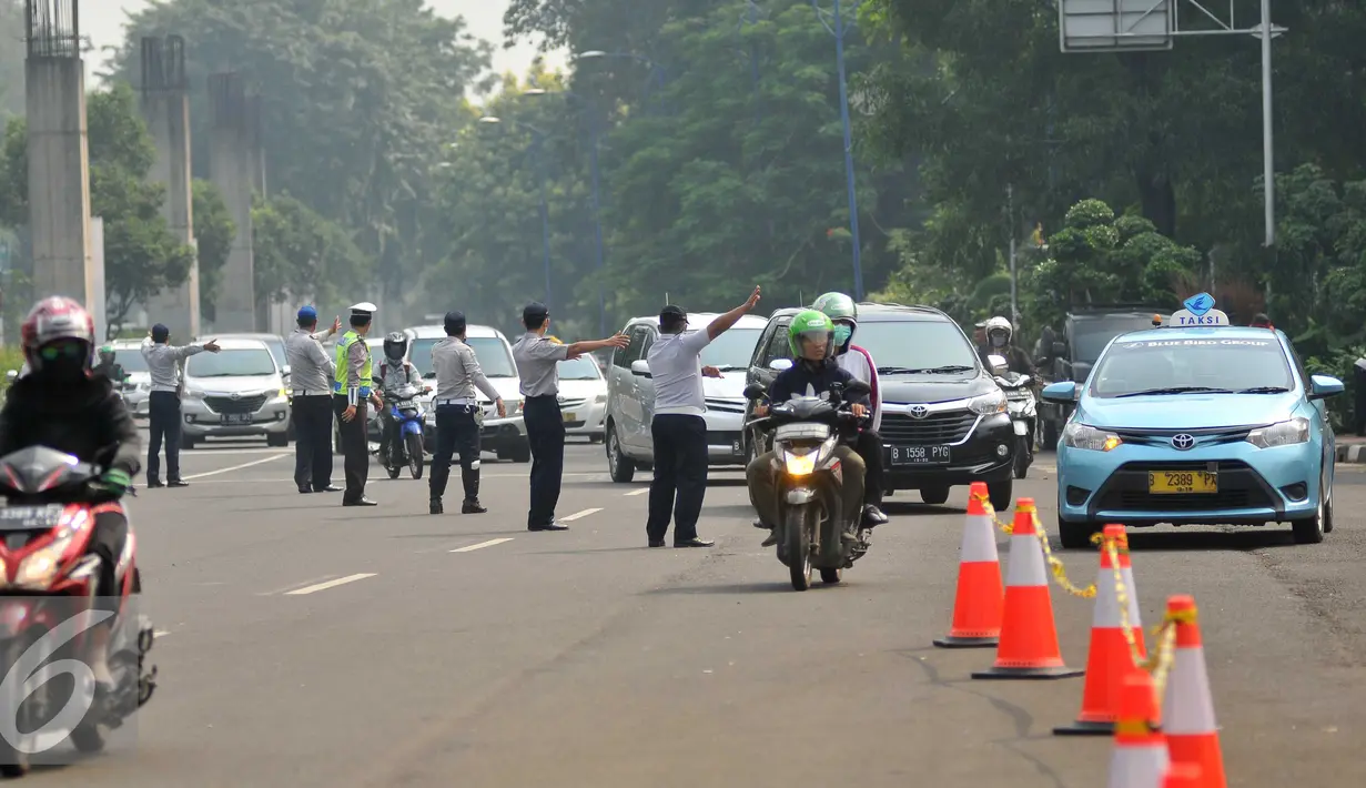Petugas mengatur lalu lintas pada saat uji emisi di pintu satu Gelora Bung Karno, Jakarta, Selasa (17/5). Pemkot Administrasi Jakpus melakukan uji emisi kendaraan selama tiga hari untuk mengevaluasi kualitas udara perkotaan. (Liputan6.com/Gempur M Surya)