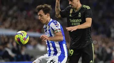 Gelandang Real Madrid Dani Ceballos berebut bola dnegan penyerang Real Sociedad  Mikel Oyarzabal pada pekan ke-33 Liga Spanyol 2022/2023 di Reale Arena, Rabu (3/5/2023) WIB.  (AP Photo/Alvaro Barrientos)