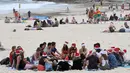 <p>Sejumlah orang berkumpul mengenakan topi Santa Claus saat merayakan hari Natal di Bondi Beach Sydney, Australia (25/12). (Dean Lewins / AAP Image via AP)</p>