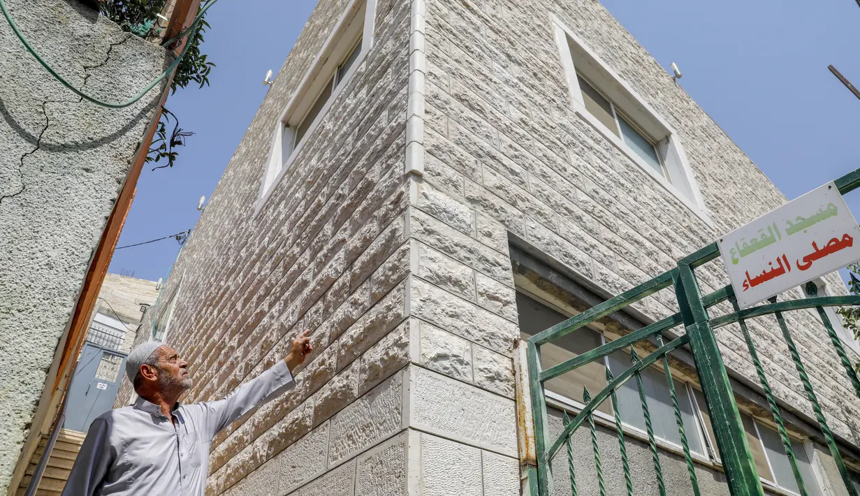 Seorang muazin menunjukkan kondisi Masjid Qaqaa Bin Amr yang akan digusur Israel di lingkungan Silwan yang sebagian besar orang Arab di Yerusalem timur (15/9/2020). Pengadilan Israel memerintahkan penggusuran pada Masjid Qaqaa Bin Amr yang berdiri di Silwan, Yerusalem. (AFP/AHMAD GHARABL)