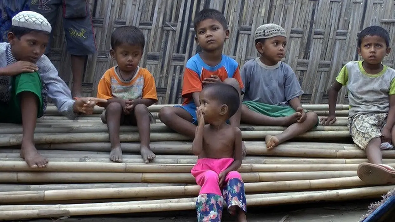 Anak-anak Rohingya tengah duduk di atas tumpukan pohon bambu di kamp pengungsi Dar Paing, di utara Sittwe, Rakhine