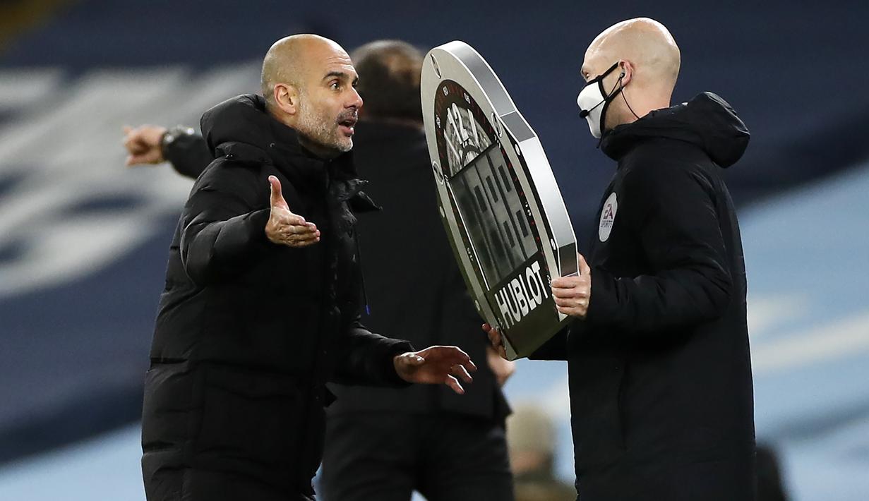 Pelatih Manchester City, Pep Guardiola, berbicara kepada ofisial wasit saat pertandingan melawan West Brom pada laga lanjutan Liga Inggris di Etihad Stadium, Rabu (16/12/2020). Pep Guardiola melakukan protes karena durasi injury time yang dianggap sedikit. (AFP/Clive Brunskill/pool)