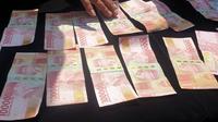 Sejumlah barang bukti berupa uang pecahan Rp 100 ribu hasil penangkapan dari tersangka HH, mucikari PSK di kawasan wisata Cipanas, Garut, Jawa Barat. (Liputan6.com/Jayadi Supriadin)