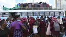Anak-anak sekolah menunggu untuk naik bus menuju sekolah di Harare, Minggu (6/2/2022). Sekolah-sekolah di Zimbabwe dibuka kembali pada 7 Februari setelah penundaan selama berminggu-minggu dalam mengizinkan siswa kembali menyusul meningkatnya infeksi COVID-19. (AP Photo/Tsvangirayi Mukwazhi)