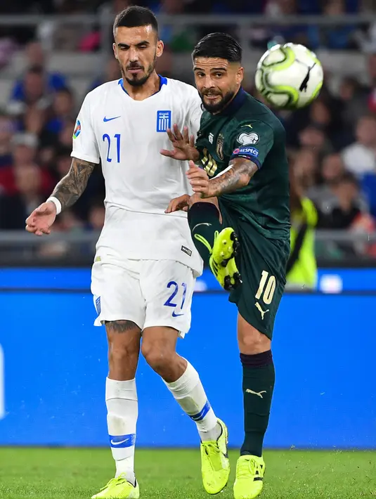 Pemain timnas Yunani Dimitrios Kourbelis berebut bola dengan penyerang timnas Italia, Lorenzo Insigne pada pertandingan grup J babak kualifikasi Piala Eropa 2020 di Stadio Olimpico, Sabtu (12/10/2019). Italia lolos ke putaran final setelah mengalahkan Yunani, 2-0. (Alberto PIZZOLI / AFP)