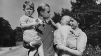 File foto Agustus 1951 ini, Ratu Inggris Elizabeth II berdiri bersama suaminya Pangeran Philip dan anak-anak mereka, Pangeran Charles dan Putri Anne di Clarence House, kediaman pasangan kerajaan di London. Pangeran Philip meninggal dunia di usia ke-99 pada 9 April 2021. (AP Photo/Eddie Worth, File)