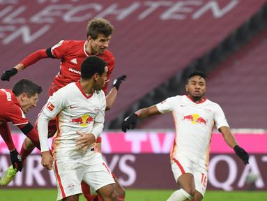 Striker Bayern Munich, Thomas Mueller, mencetak gol penyeimbang 3-3 lewat tandukan kepala dalam laga lanjutan Liga Jerman pekan ke-10 melawan RB Leipzig di Allianz Arena, Sabtu (5/12/2020). Bayern Munich bermain imbang 3-3 dengan RB Leipzig. (AFP/Andreas Gebert/Pool)